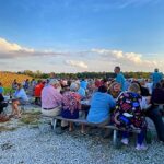 People on picnic tables at Caesar Creek Vineyard at Raise a Glass to Reading event