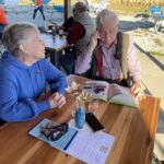 Attendees look over brochure at Raise a Glass to Reading