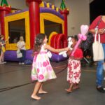 two young girls play together with their balloon art