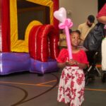 young girl holds balloon art