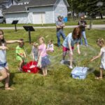 kids play with big bubbles on lawn