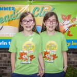 Twin girls wear matching summer reading club shirts