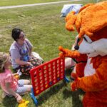 woman and girl play connect four with Booker the Fox mascot