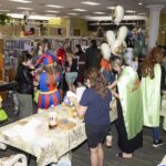librarians serving butter beer floats and doing crafts with teens at Harry Potter booth