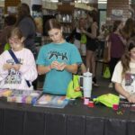 three girls make friendship bracelets
