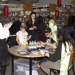 Group of teens at table with trading cards