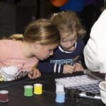 two girls make bracelets