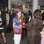 teen dressed as jester poses while friend takes photo
