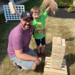 man and young boy play giant benga