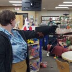 Woman holds her arm out for a flying hawk to land on