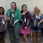 Painting party group poses with their final chicken paintings