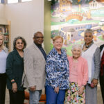 GCPL Board, Karl Colón, and Elizabeth Cusack pose in front of mural in Youth Services area of Xenia library