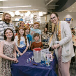 Librarian Em doing a demonstration to a group of adults and kids