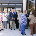 group of adults converse in front of Xenia library entrance