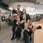 family poses in youth section of Xenia library