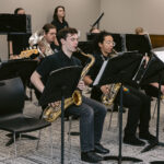 high school band students playing saxophone