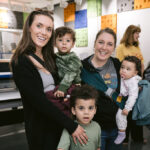 Two women and three young children pose together in Spark Place