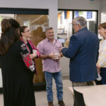 adults converse in front of Spark Place entrance