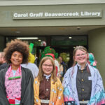 3 teens dressed as anime characters posed outside the library entrance