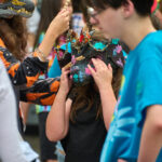 teen in dragon mask waiting to check in