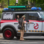 Teen dressed up as a ghostbuster gets into ghostbuster jeep