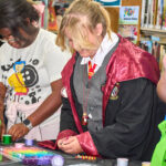 Teen in Gryffindor costume makes beaded craft