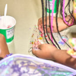 teen makes decorates keychain with sticky gems