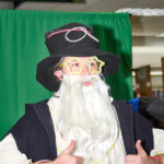 Teen with fake white beard & star glasses gives two thumbs up