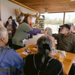 Staff volunteer chatting to table of attendees