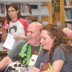 couple smiling while trivia host speaks in background