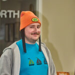library staff Ben H. wearing a beanie smiling at camera