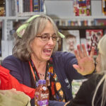 Fairborn librarian Karen Tracy Jeffers smiling high fiving trivia player