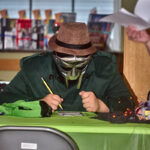 Masked patron writing down trivia answers