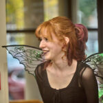 staff member in fairy wings smiling