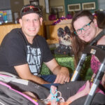 man & woman smiling, baby in a stroller