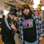 Mike on the left in a tracksuit and Mike on the right in a mullet wig and MTV tv shirt