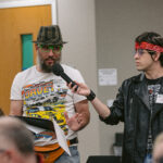 Actor playing the Rockstar standing and holding microphone out to attendee