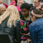 group of attendees sitting and putting their heads together to discuss clues