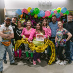 Group of attendees in front of the 80s photo station