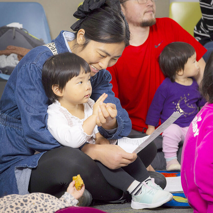child sits on woman's lap during storytime