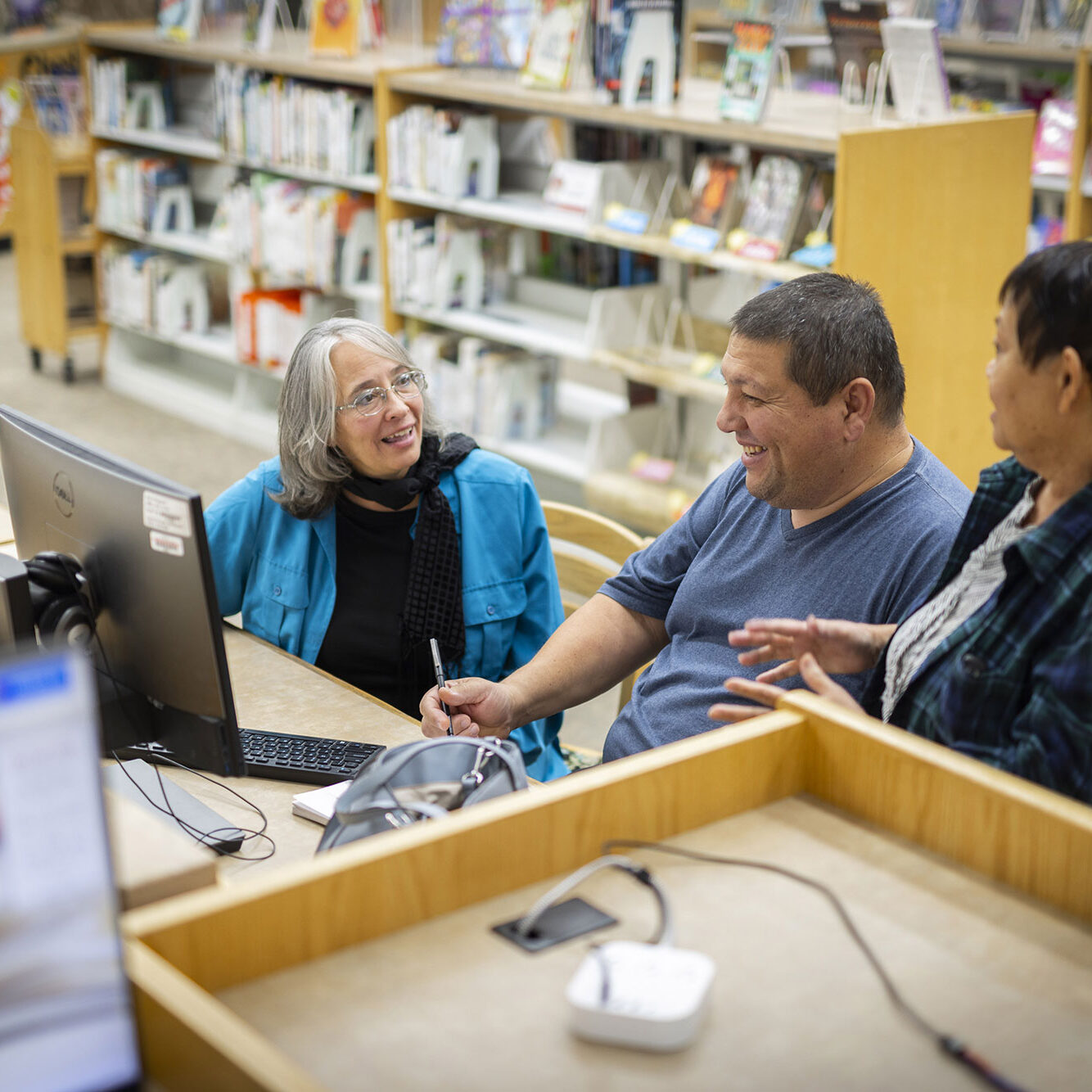 Librarian helping patrons on a computer